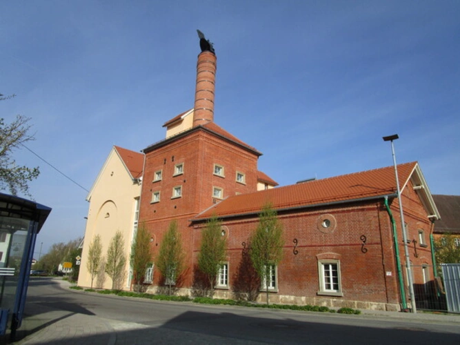 Sicht von der Straße auf Zahnarztpraxis in niederem, rotem Gebäudeteil
